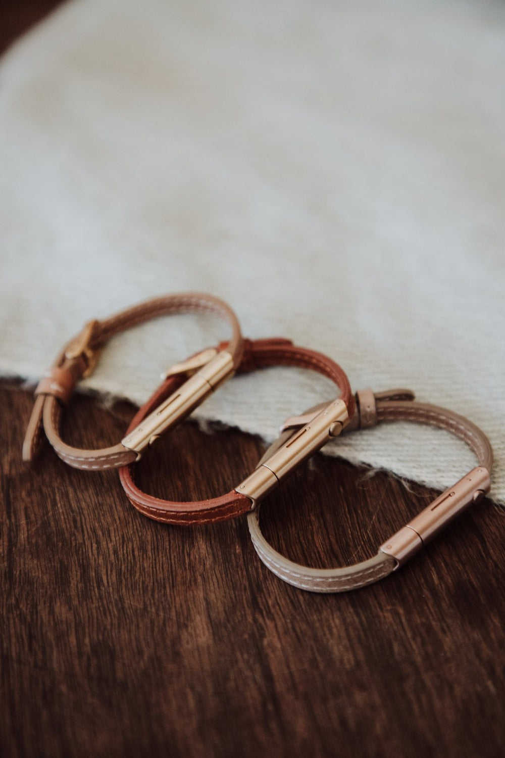 Drie Invi Classic armbanden op een houten tafel